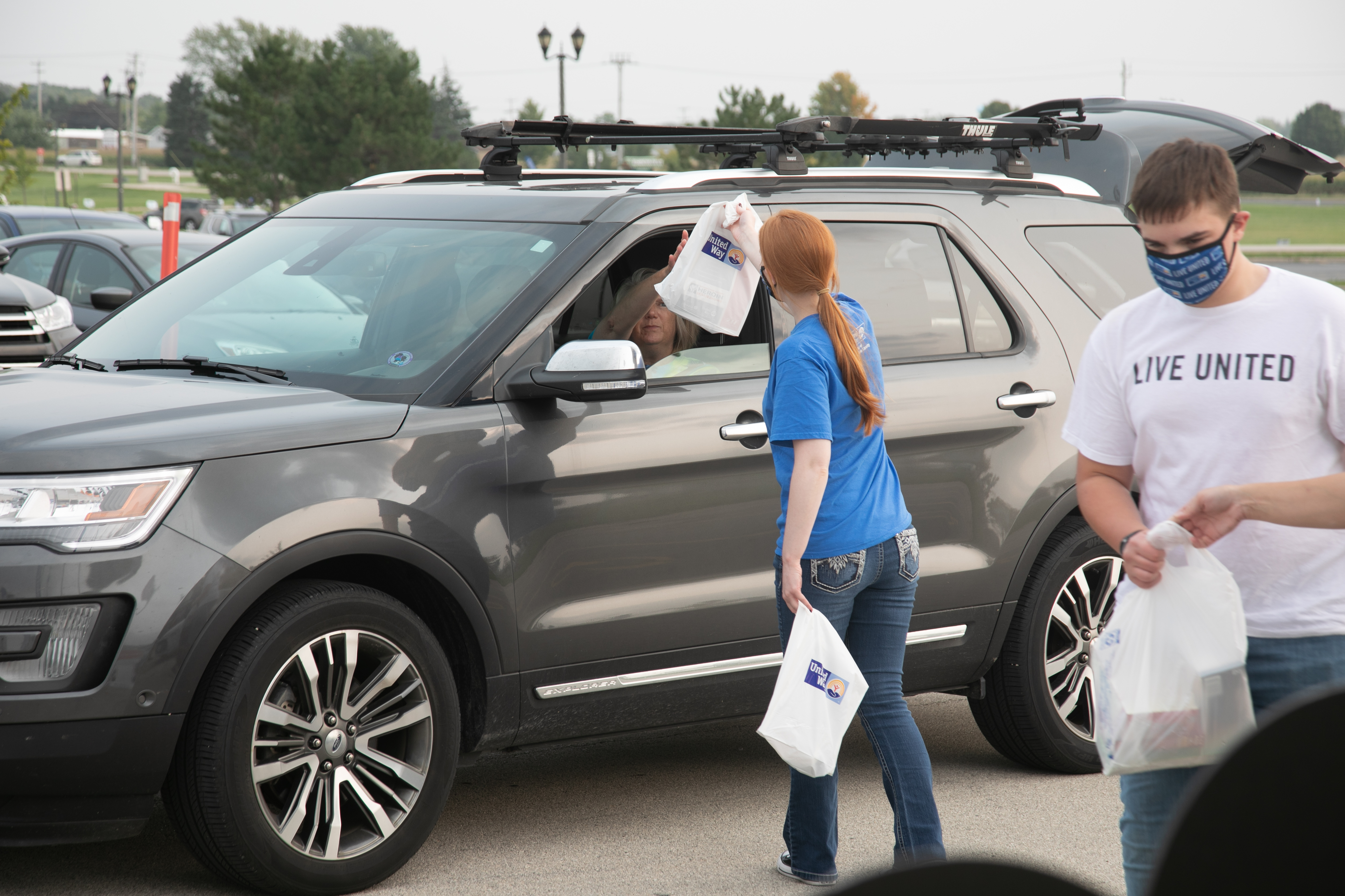 Photo of someone in van dropping off food for food drive.